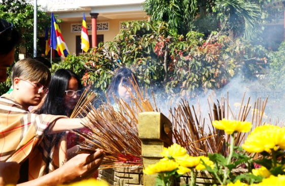 Ảnh cận cảnh bàn thờ, hương khói nghi ngút, người đang chắp tay khấn vái trang nghiêm