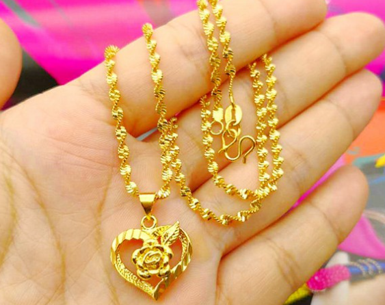 Bức ảnh một bàn tay cầm dây chuyền vàng, xung quanh là ánh sáng rực rỡ tượng trưng cho vận khí tốt lành.