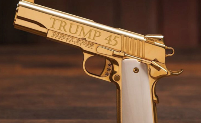 Bức ảnh chụp cận cảnh khẩu súng lục mạ vàng sáng bóng, ánh sáng phản chiếu rực rỡ.