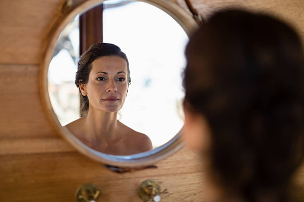 Hình ảnh minh họa người phụ nữ soi gương, thể hiện sự tự nhận thức và khám phá bản thân