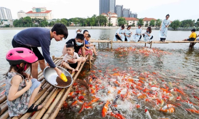 Người cười vui vẻ bên ao cá, biểu trưng cho thành công và hạnh phúc viên mãn.