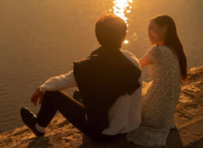 Hình ảnh chàng trai và cô gái ngồi trò chuyện trong không gian lãng mạn, thể hiện sự thấu hiểu